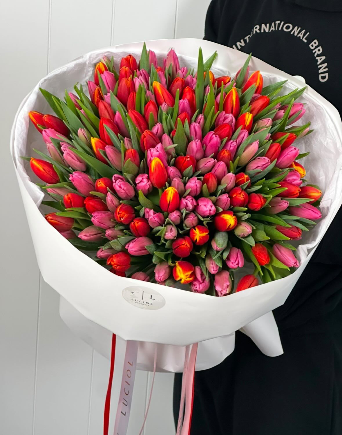 Red and pink tulip bouquet in white wrapping by Luciol Bouquets – Seattle flower delivery