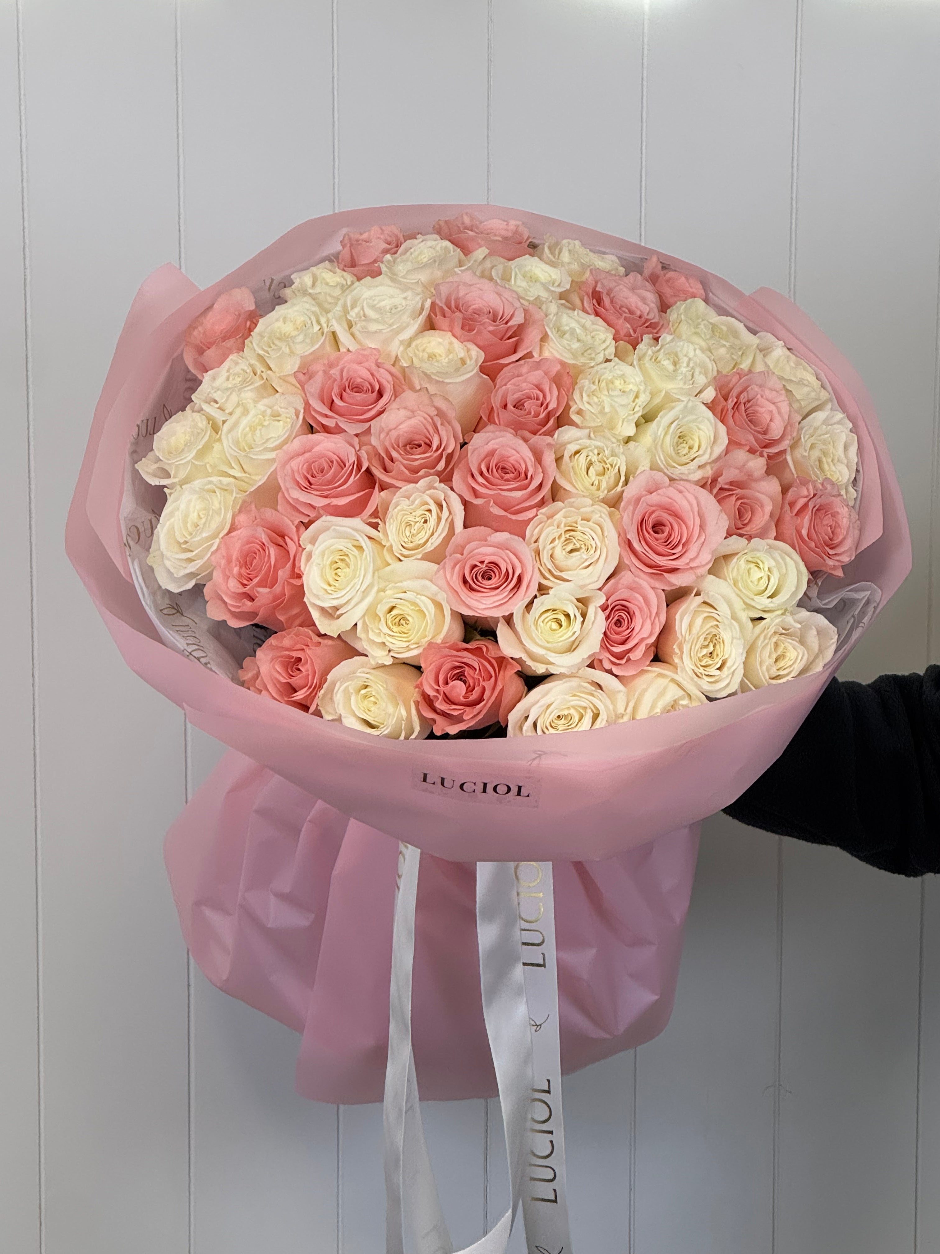 White and pink roses bouquet in pink wrapping by Luciol Bouquets – flower delivery Seattle and Bellevue