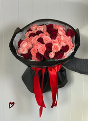 Valentine’s Day bouquet with red roses and Isabella spray roses in black wrapping by LUCIOL